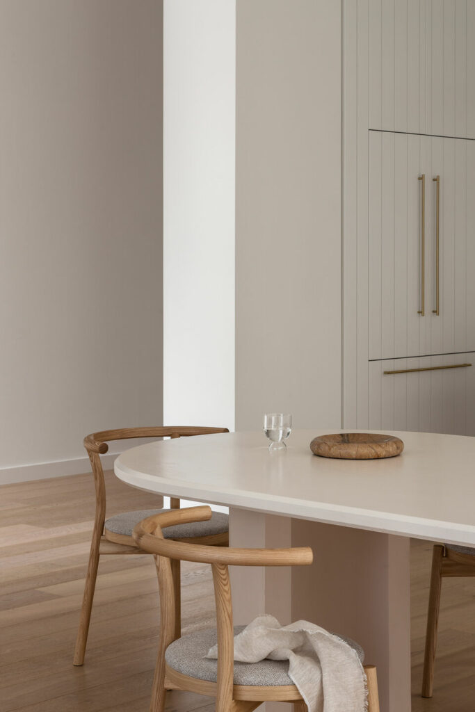 oval dining table with wishbone chairs creating a minimalistic and clean dining area